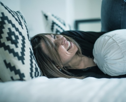 vrouw lachend in bed
